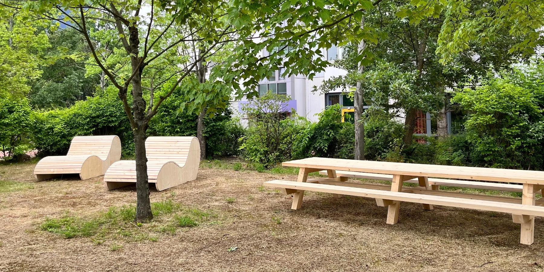 Holzmodule und Sitzbänke auf einem Schulgelände